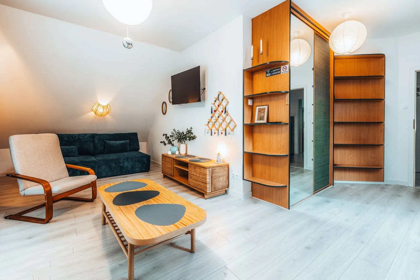 Salon z zapalonymi lampami, telewizorem i fotelem